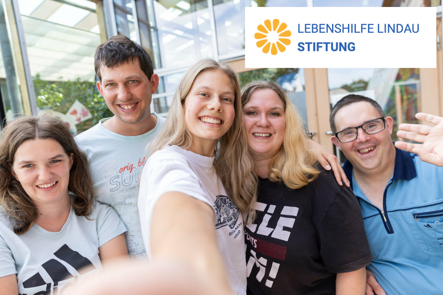 Lebenshilfe Lindau Stiftung Ein Selfie von mehreren Personen mit dem Logo der Stiftung Lebenshilfe