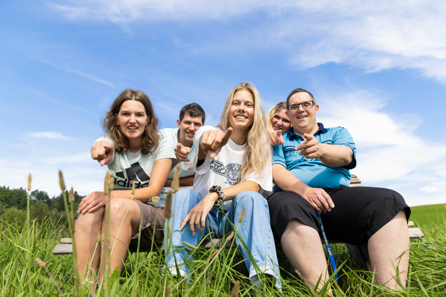 Auf der Wiese Mehrere Personen sitzen im Freien auf einer Wiese