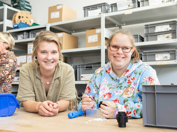 Zwei Frauen vor einem Regal in einer Werkstatt
