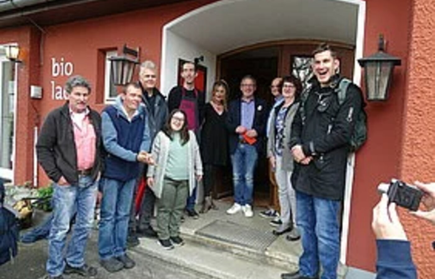 Eine Personengruppe steht vor einem Café