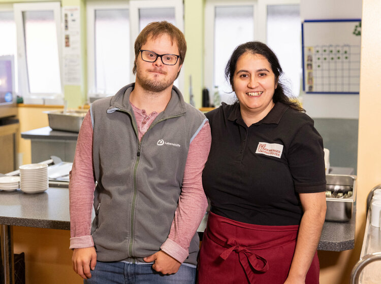Ein Mann und eine Frau stehen vor einem Tisch mit Geschirr