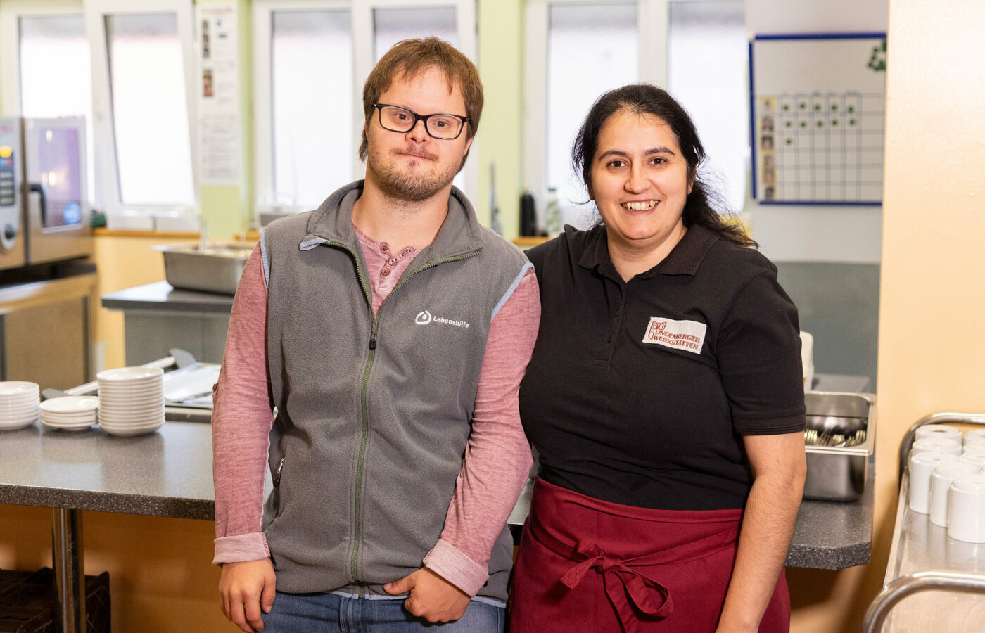 Ein Mann und eine Frau stehen vor einem Tisch mit Geschirr